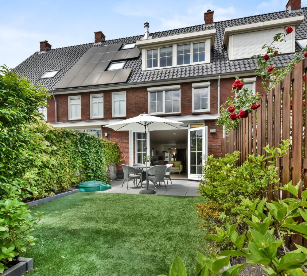 Back yard in a cozy house with a small sitting area and a garden