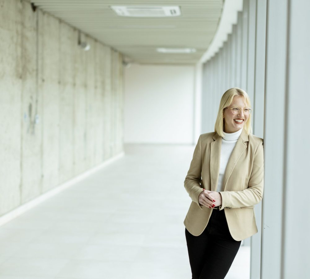 Young business woman standing in the office corridor