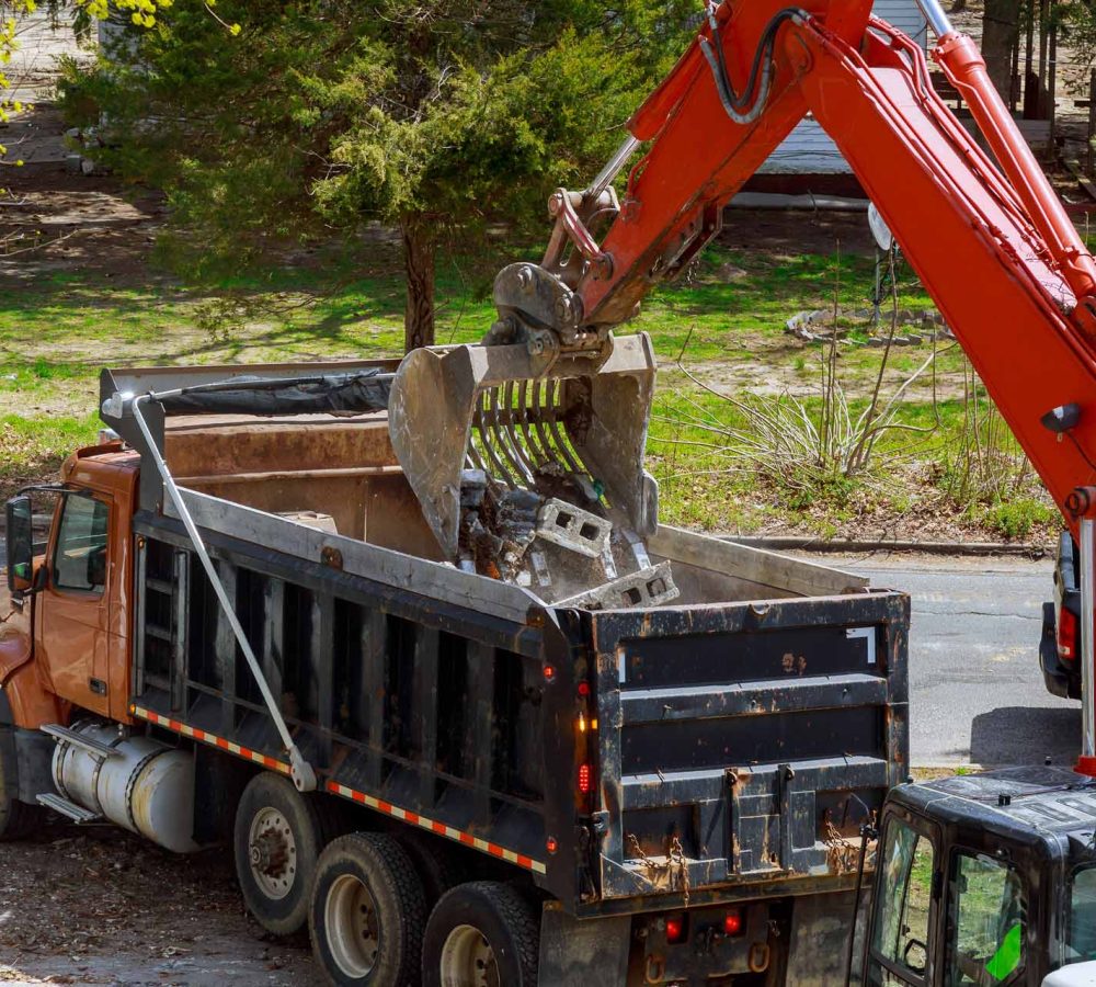excavator-picks-up-construction-waste-for-loading-CVPJ63X.jpg
